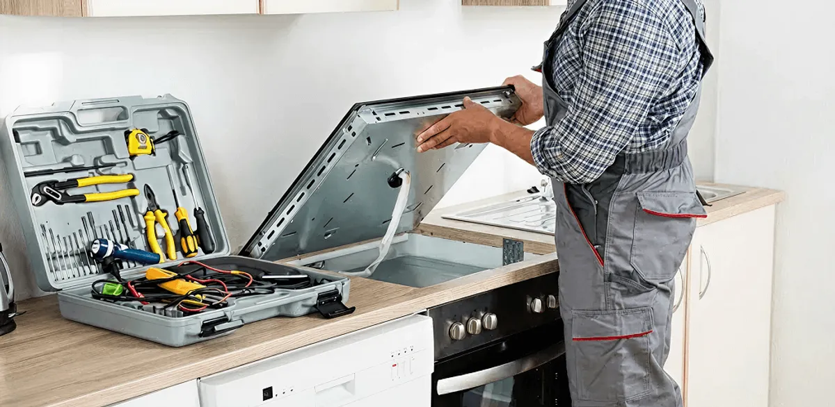 Handyman repairing a cooktop and checking wiring connections in Grand Rapids, MI