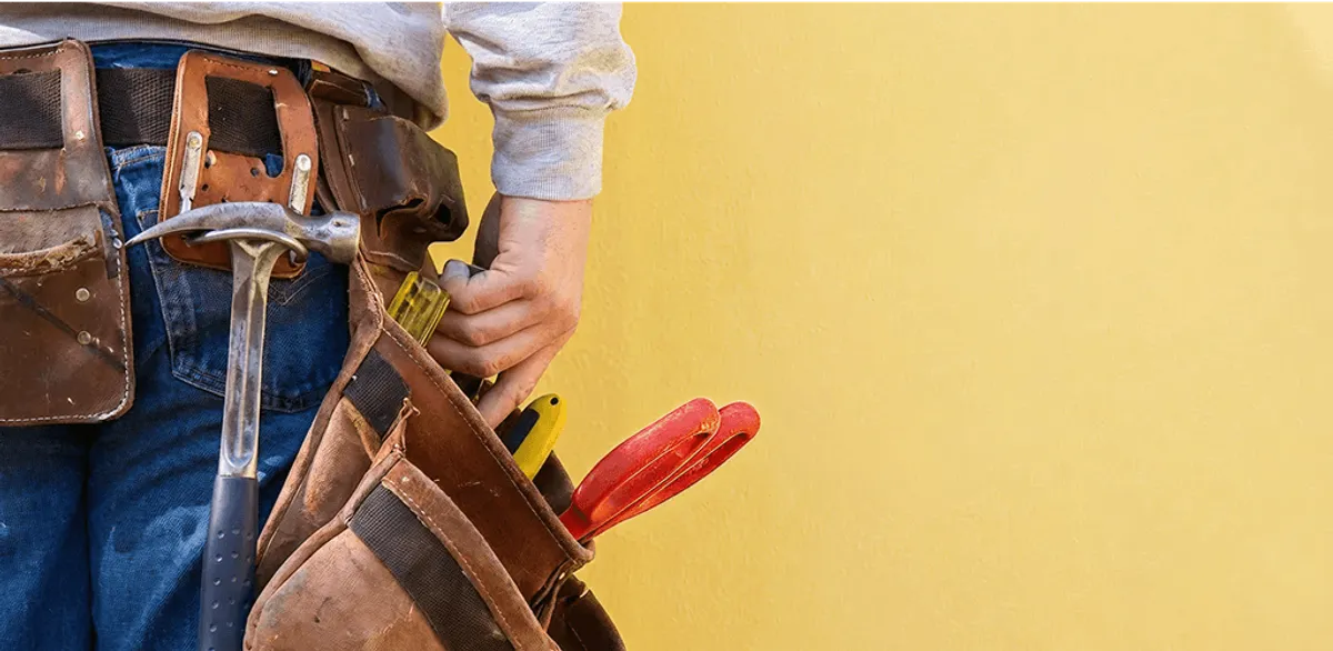 Handyman with tool belt ready for home repairs and maintenance in Grand Rapids, MI