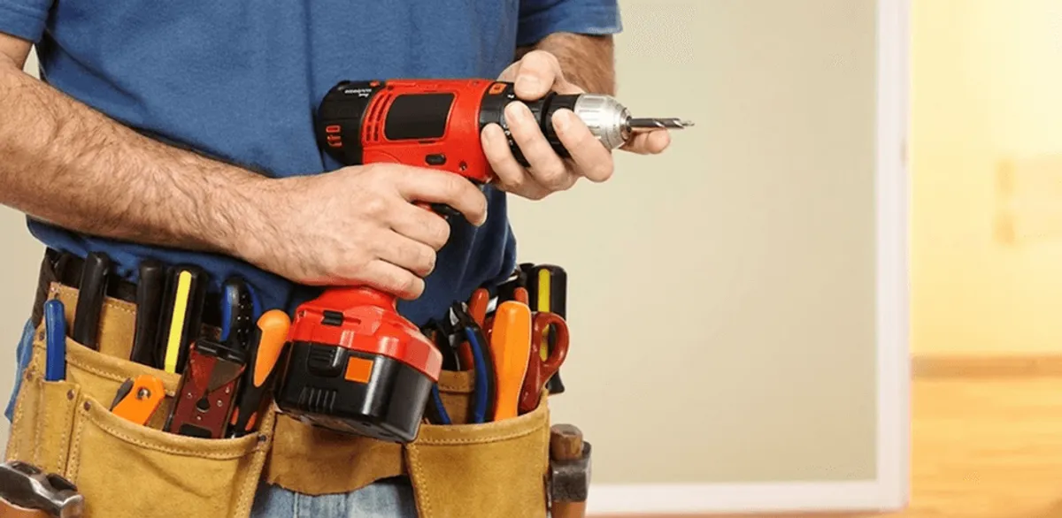 Handyman holding a power drill for home repairs and installations in Grand Rapids, MI